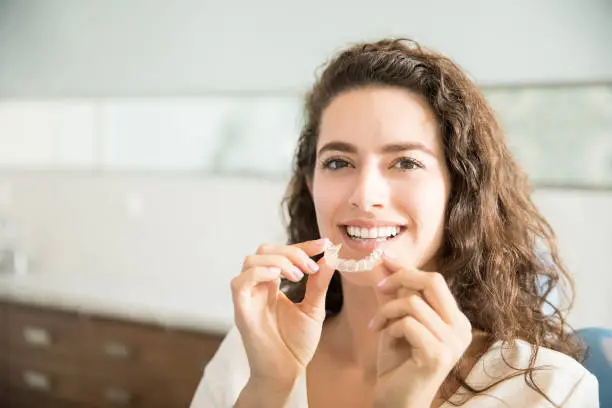 Woman ready to place aligners purchased with our Invisalign Payment Plan