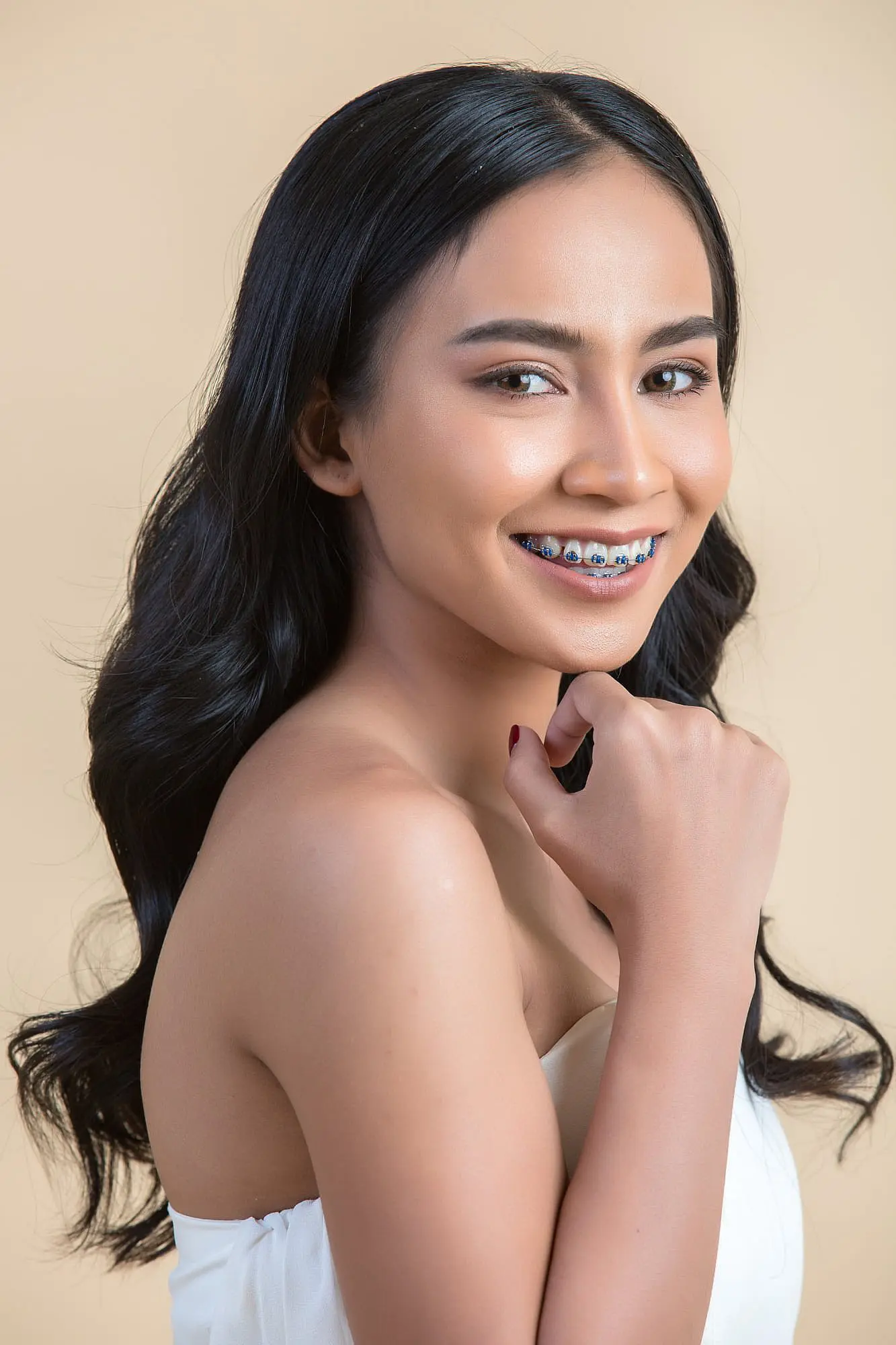 A smiling young woman, who appears to be of Southeast Asian descent based on her features and complexion, shows her braces. Limestone Hills Orthodontics in Austin, TX.