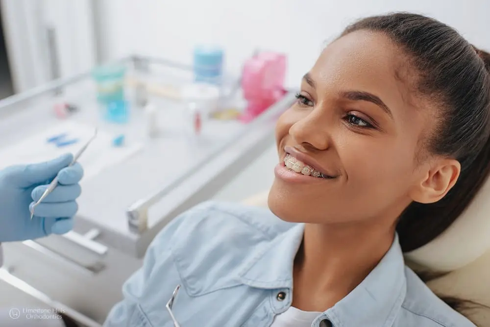 Orthodontist holding dental instruments while treating a happy African American patient after she knows how to speed up orthodontic treatment