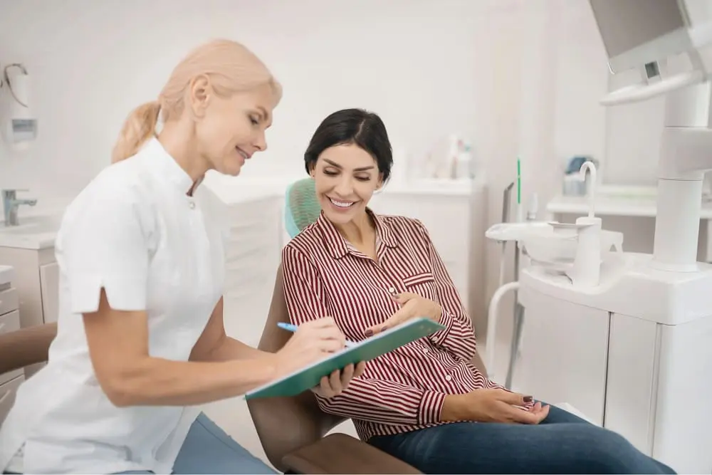 Patient discussing her dental treatment with an orthodontist in a bright clinic as one of the orthodontic consultation process