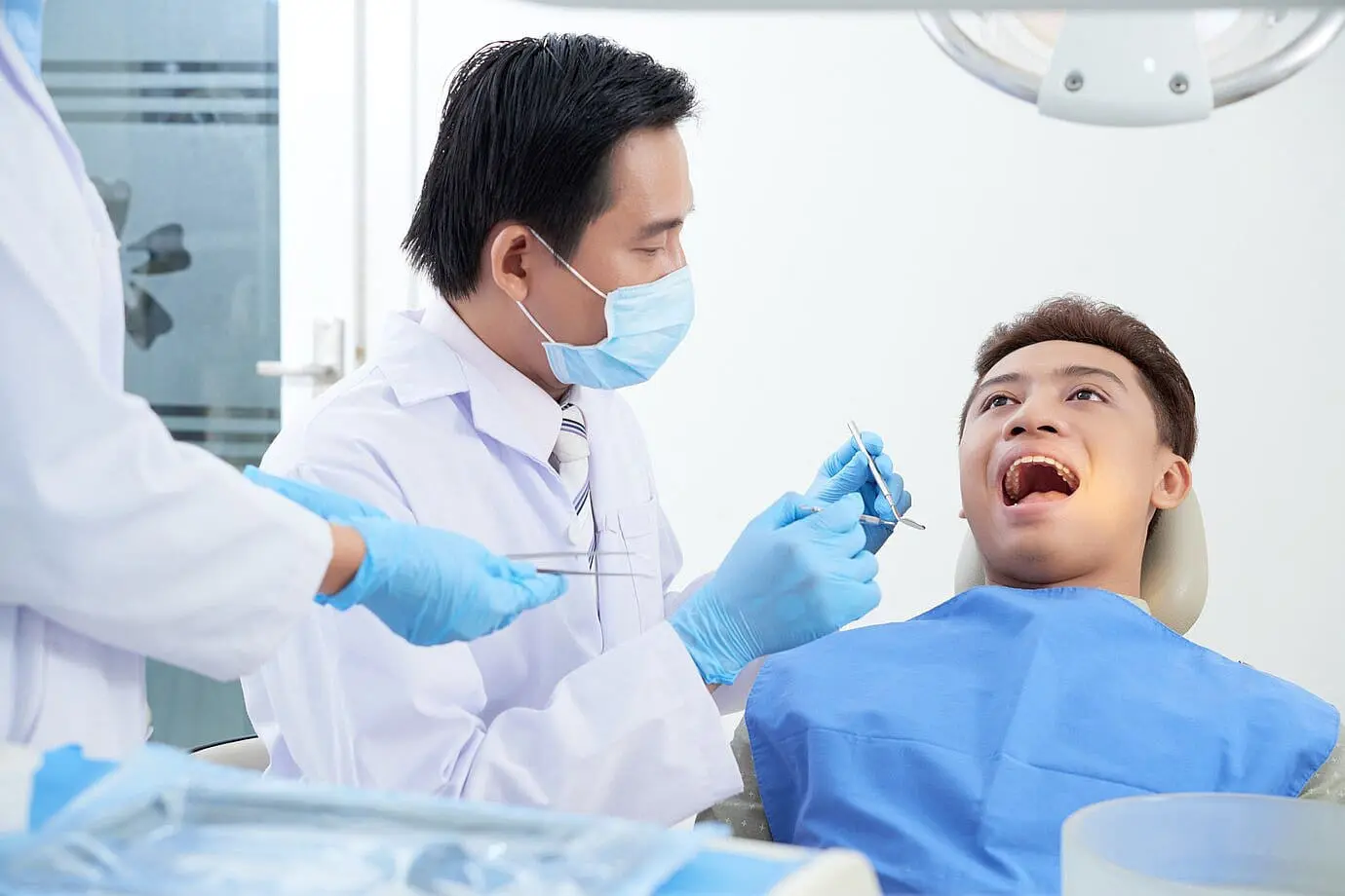 Dentist examining a patient’s open mouth during an orthodontic evaluation to identify different Types of Tongue Thrust at Limestone Hills Orthodontics in Austin, TX.