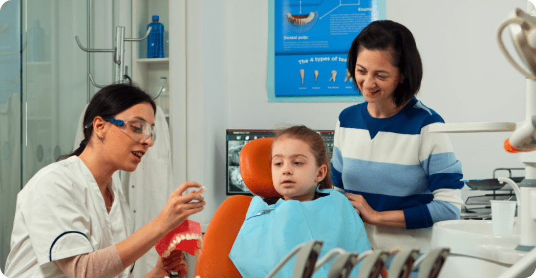 Dentist explains early orthodontic care to a young girl at Limestone Hills Orthodontics in Austin, TX.