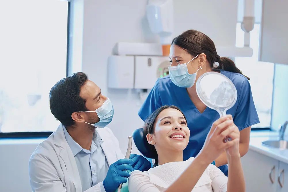 At Limestone Hills Orthodontics in Austin, TX, a woman smiles in a dental chair with masked staff nearby, highlighting How Orthodontics Supports Your Overall Health in Austin, TX.